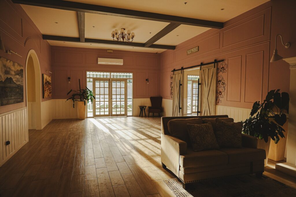 Explore a sun-drenched luxury rustic interior featuring a sophisticated sofa and large windows with abundant natural light.
